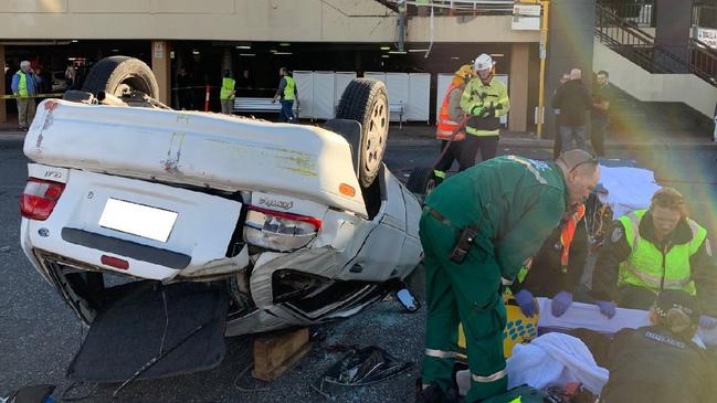 An overturned car which crashed over the barrier on the first level of the Westfield Marion car park. Picture: AAP / SA Police