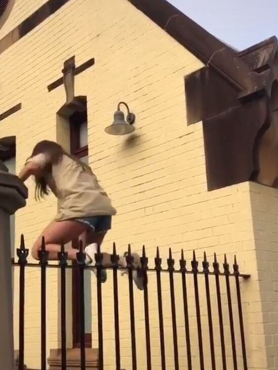 Another student trespasses when she jumps over a fence.