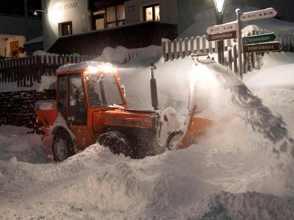 Workers use heavy machines to clear huge masses of snow from the streets of St. Anton am Arlberg. Picture: Joe Klamar/AFP