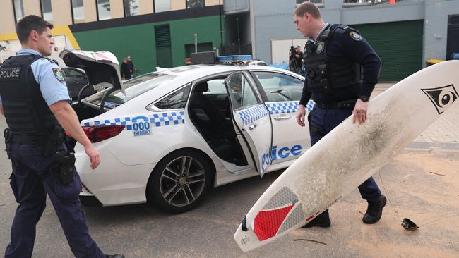 Police recover the surfboard belonging to a 44-year-old man from Sydney’s Upper North Shore who drowned at Collaroy Beach on Monday afternoon. His family told police he had taken up the sport two years ago. Picture John Grainger