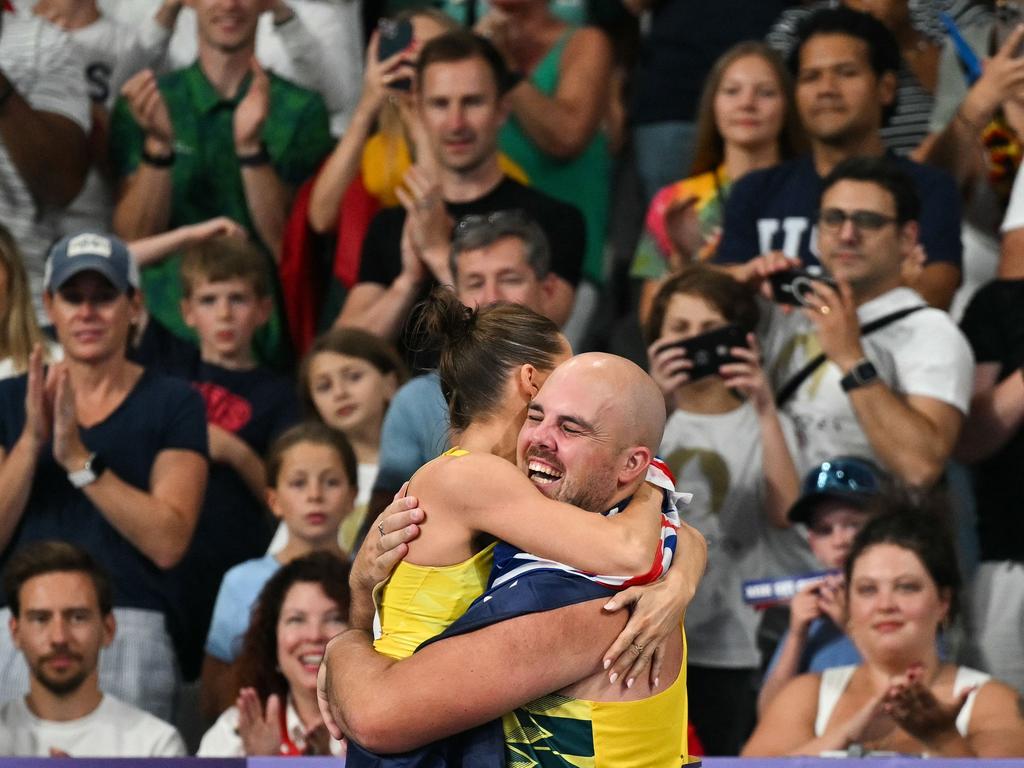 After winning gold for Australia in pole vault, Nina Kennedy rushed to embrace teammate Matt Denny after he held on for the bronze medal in men's discus throw event. Picture: Andrej Isakovic/AFP