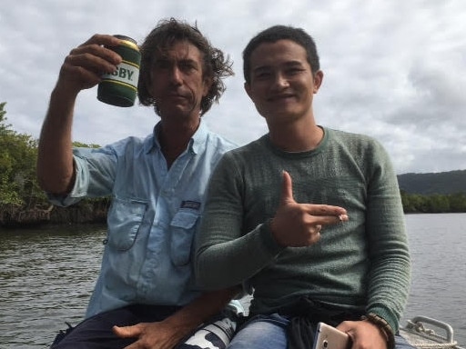 Justin Ward sharing a beer and a cigarette with an asylum seekers, believed to be from Vietnam, rescued from mangroves in the Daintree River