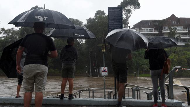 Onlookers observe the inclement conditions at the weir. Picture: Bianca De Marchi