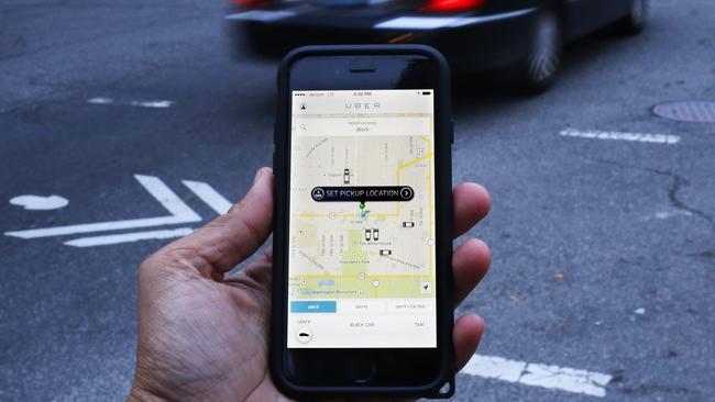 (FILES) This file photo taken on March 25, 2015 shows an UBER application being shown as cars drive by in Washington, DC. Quebec taxi drivers went to court February 2, 2016 seeking a permanent injunction banning Uber in the Canadian province, in just the latest legal challenge against the ride-sharing app in several countries.The union representing 4,000 taxi drivers in Quebec says Uber is illegal and wants it shut down locally and is also considering launching a class-action lawsuit against the startup to recover lost revenue. / AFP / Andrew Caballero-Reynolds