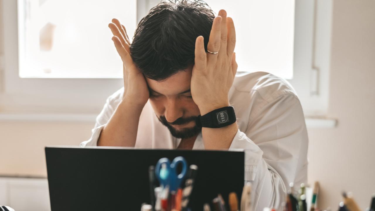 Tired frustrated exhausted businessman working from home online sitting at home office with laptop during quarantine and self isolation period at pandemic. Crisis management. Despair of market falling down.