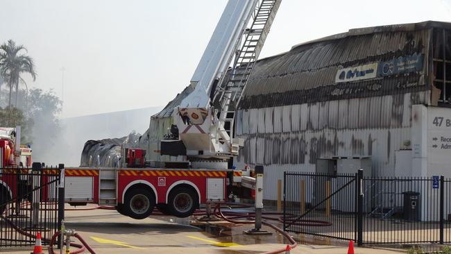 Smoke continues to billow from the gutted food supply warehouse well into the morning