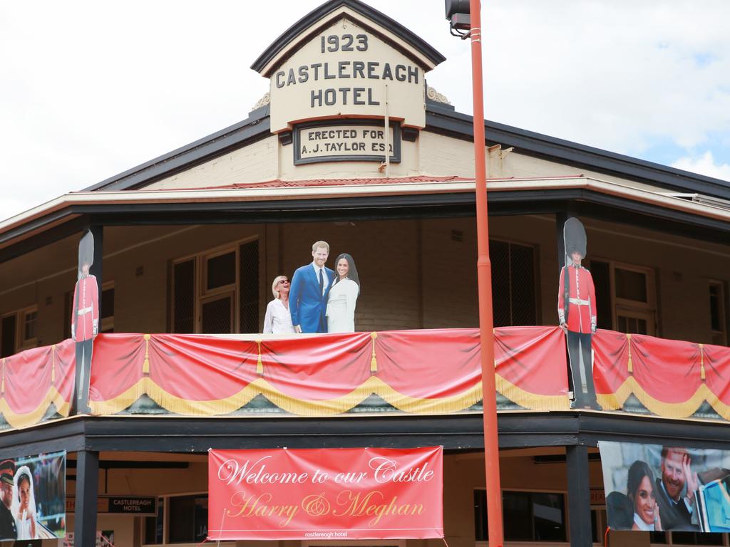 A woman stands next to a cardboard cut out of the royal couple on the balcony of the Castlereagh Hotel. Picture: Toby Zerna.