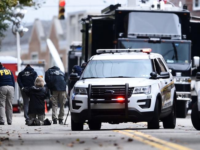 Members of the FBI survey the street on October 28, 2018 outside of the Tree of Life synagogue after a shooting there left 11 people dead in the Squirrel Hill neighborhood of Pittsburgh on October 27, 2018. - A man suspected of bursting into a Pittsburgh synagogue during a baby-naming ceremony and gunning down 11 people has been charged with murder, in the deadliest anti-Semitic attack in recent US history. The suspect -- identified as a 46-year-old Robert Bowers -- reportedly yelled "All Jews must die" as he sprayed bullets into the Tree of Life synagogue during Sabbath services on Saturday before exchanging fire with police, in an attack that also wounded six people. (Photo by Brendan SMIALOWSKI / AFP)