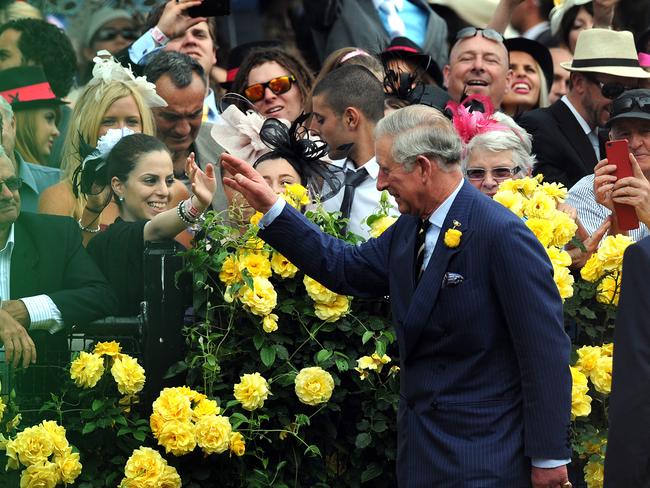 The Prince of Wales greets a spectator in the mounting yard before the start of the Melbourne Cup in 2012. Picture: AAP Image/Joe Castro