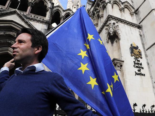 Pro-European Union (EU) supporter Phil Jones holds an EU flag outside the entrance to The Royal Courts of Justice, Britain's High Court, in London on October 13, 2016, during a protest against the UK's decision to leave the EU. The battle over Britain's exit from the European Union (Brexit) reached the High Court on Thursday in a legal challenge to Prime Minister Theresa May's right to start negotiations for Britain to leave the EU without a vote in parliament. The move could delay Brexit if successful and set up an unprecedented constitutional face-off between the courts and the government. / AFP PHOTO / ADRIAN DENNIS