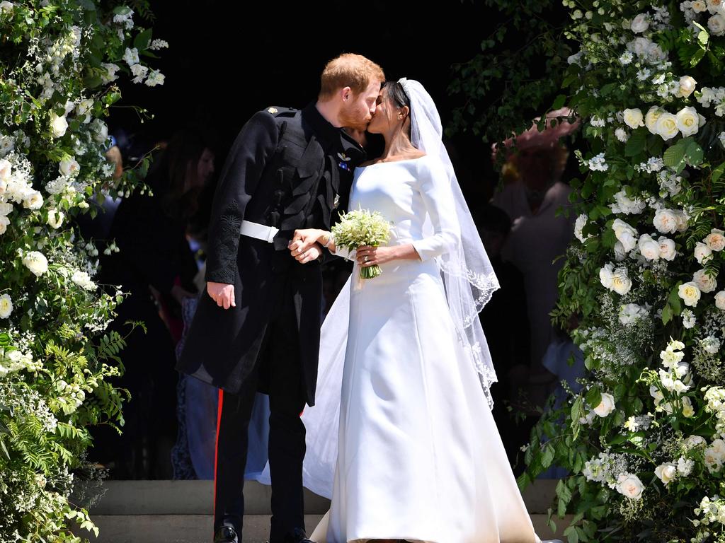 Prince Harry, Duke of Sussex kisses his wife Meghan, Duchess of Sussex as they leave from the West Door of St George's Chapel, Windsor Castle, after their wedding ceremony. Picture: AFP