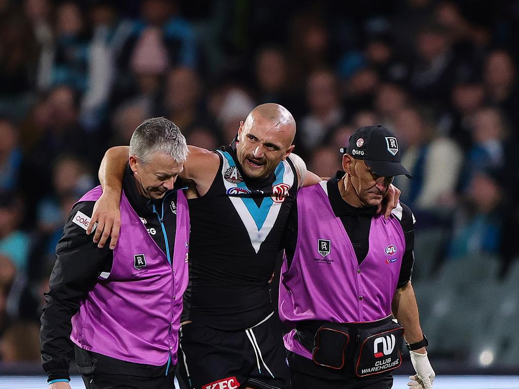 Sam Powell-Pepper of the Power in the hands of medical staff after hurting his knee. (Photo by Sarah Reed/AFL Photos via Getty Images)