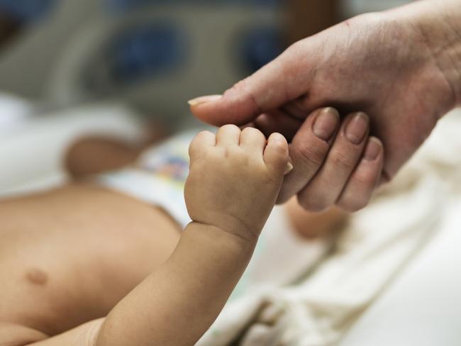 A toddler holds a hand. Picture: Rawpixel / iStock