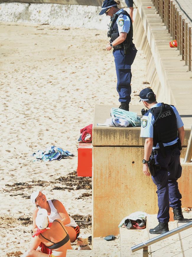 Police check on beach-goers and ask those not exercising to move on. Picture: Jeremy Piper