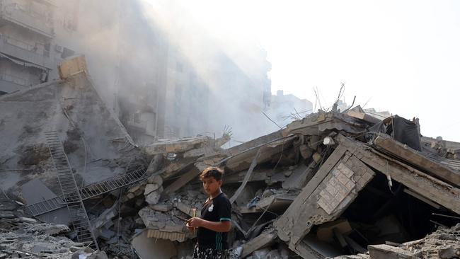 A young boy stands in front of a destroyed building in the aftermath of overnight Israeli air strikes on the Mreijeh neighbourhood of Beirut's southern suburbs on September 28. Picture: AFP