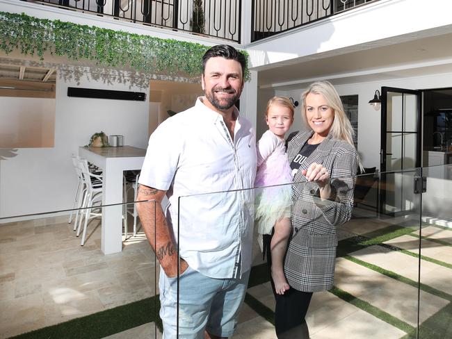 Toby Donelan, Alex Donelan and daughter London, 2, at the NY-inspired villa they are selling at Palm Beach. The couple have taken a creative approach to their renovating journey, seeking out other investors who will share in the profits from the property when it sells, thereby allowing them to fund more ambitious projects. Picture Glenn Hampson