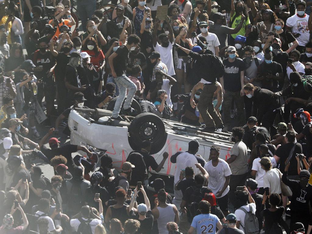 Protesters overturn a car during the Justice for George Floyd rally. Picture: Elizabeth Robertson/The Philadelphia Inquirer/AP