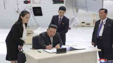 Kim Yo-jong, clutching her expensive bag, looks on as her brother signs a visitors’ book during his visit to Russia. Picture: KCNA/Korean News Service/AP