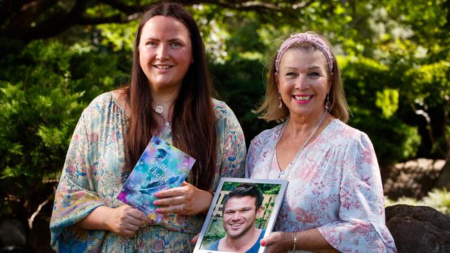 Author Cherrie Adams holds a photograph of her son Critter, with illustrator Lucinda Gregory, holding the book she wrote to honour her son. Picture: Matt Turner.