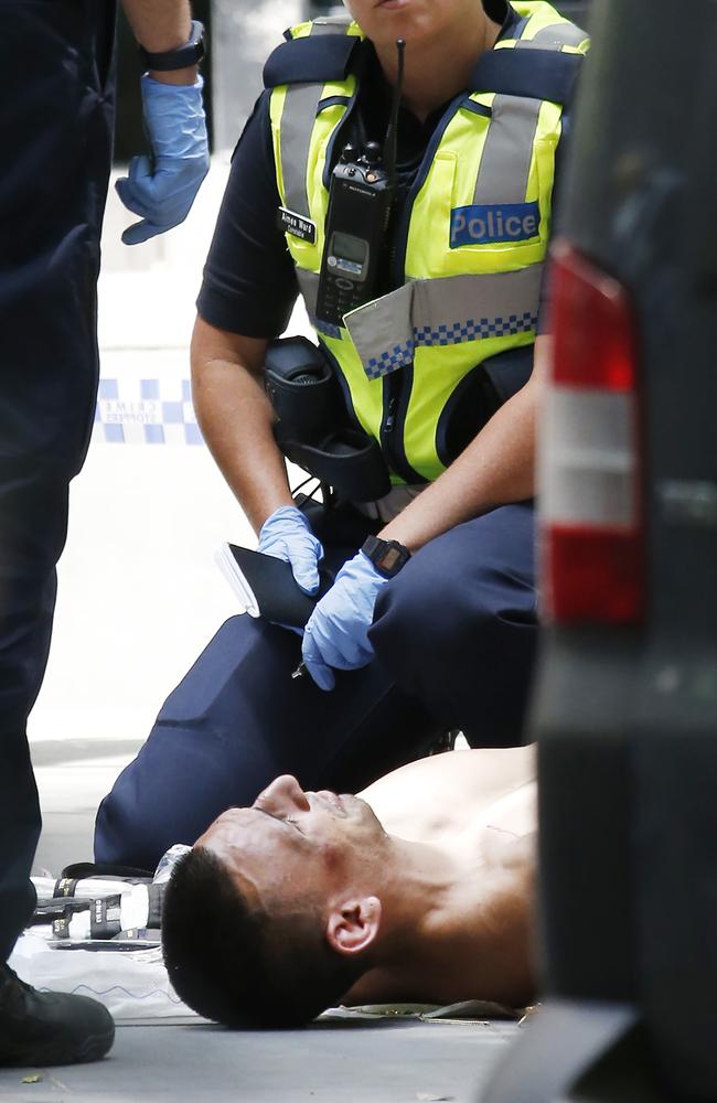 The alleged driver shot by police lies on the ground outside 535 Bourke street. Picture: David Caird