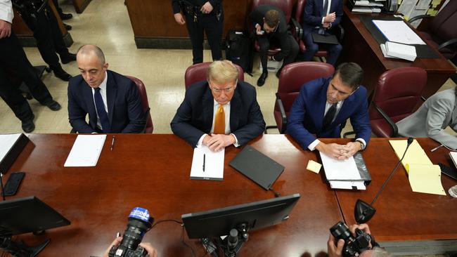 Donald Trump, sitting with attorneys Emil Bove (L) and Todd Blanche (R). (Photo by Curtis Means / POOL / AFP)