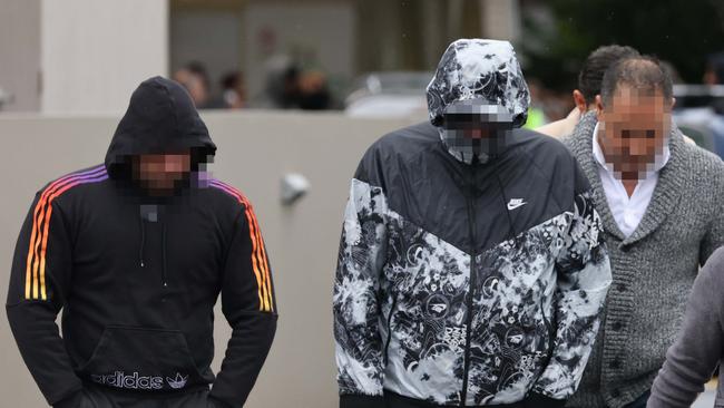 Mourners leaving the service hid their faces. Picture: David Swift