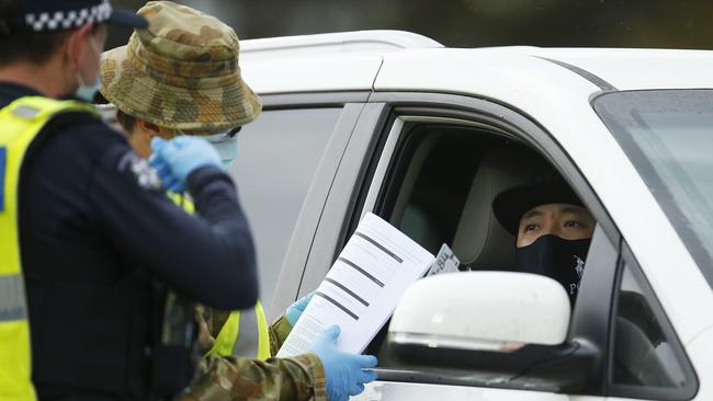 Police and ADF check work permits and identification at a roadblock in Little River on Thursday. Picture: Daniel Pockett/Getty Images