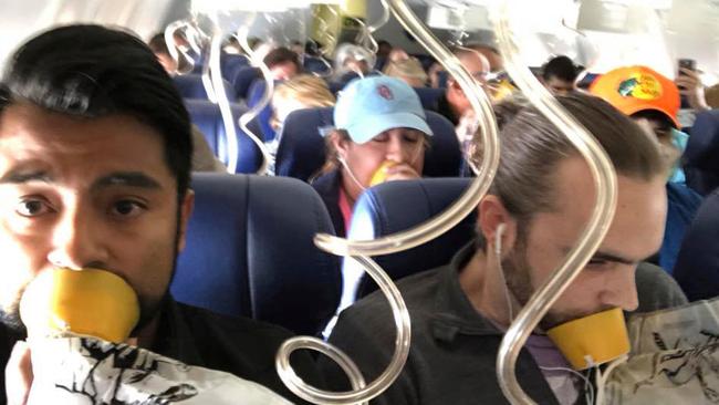 FILE- In this April 17, 2018, file photo provided by Marty Martinez, Martinez, left, appears with other passengers after a jet engine blew out on the Southwest Airlines Boeing 737 plane he was flying in from New York to Dallas, resulting in the death of a woman who was nearly sucked from a window during the flight. Video inside the cabin of the recent Southwest flight that lost cabin pressure above 30,000 feet shows many passengers improperly placing oxygen masks on their faces, putting their lives at risk. (Marty Martinez via AP, File)