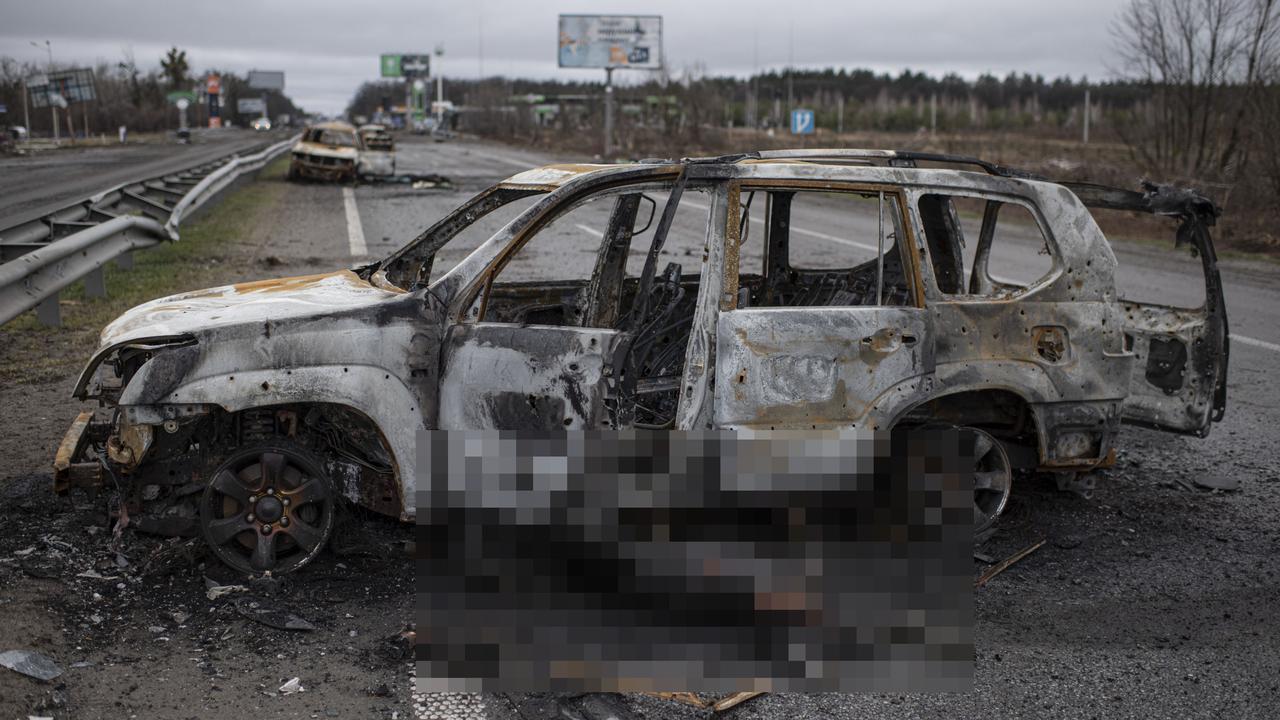 A burnt corpse is seen by a burnt car on the road between Myla and Mriia. Picture: Alexey Furman/Getty Images