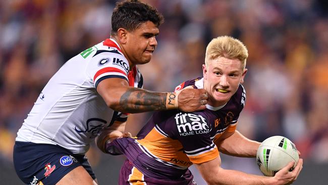 Tom Dearden (right) of the Broncos is tackled by Latrell Mitchell (left) of the Roosters during the Round 10 NRL match between the Brisbane Broncos and the Sydney Roosters at Suncorp Stadium in Brisbane, Friday, May 17, 2019. (AAP Image/Darren England) NO ARCHIVING, EDITORIAL USE ONLY