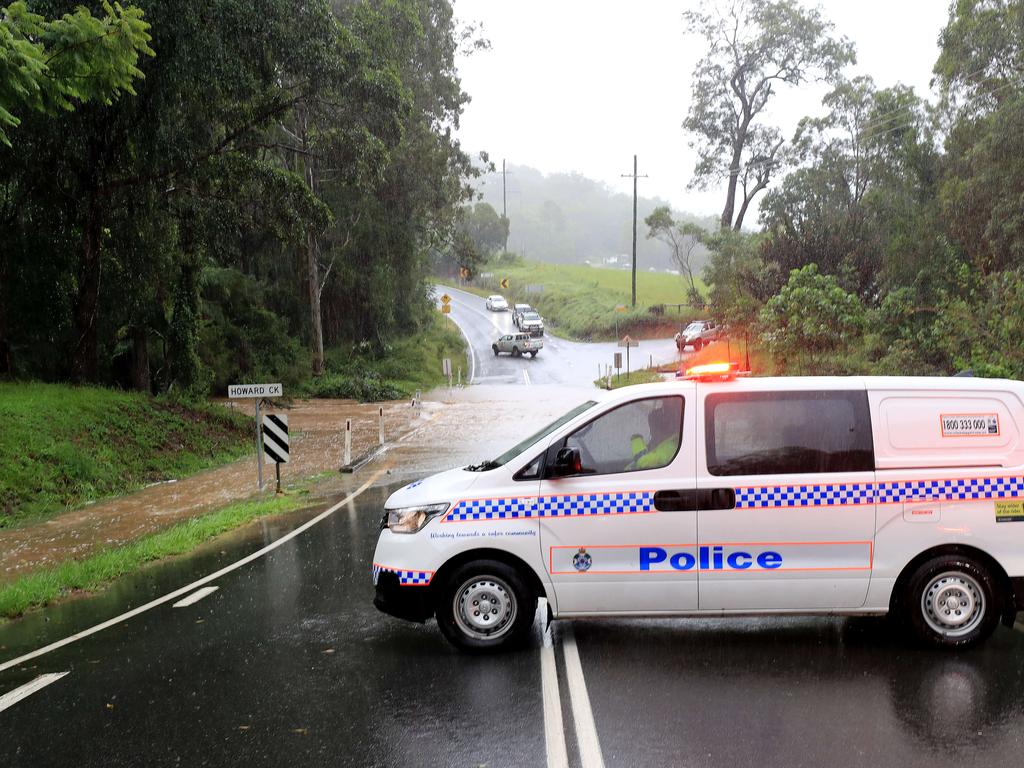 Queensland Police officers block the access to a bridge on Tamborine Oxenford Road at Wongawallen after torrential rain caused the creek to break its banks. NCA NewsWire / Scott Powick