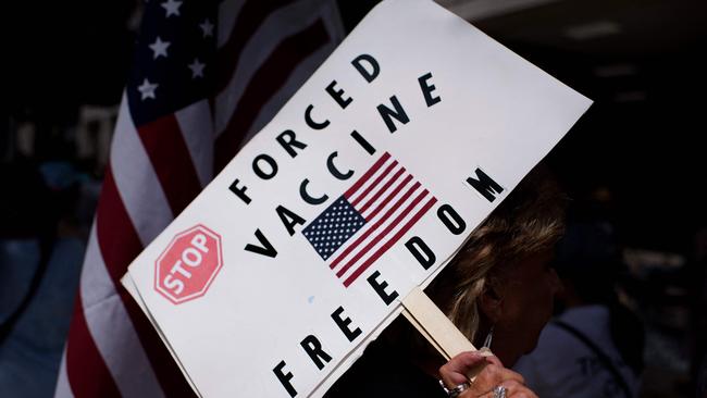 Anti-vaccine rally protesters hold signs outside of Houston Methodist Hospital in Houston, Texas in the wake of full US approval for the Pfizer/BioNTech anti-Covid vaccine . (Photo by Mark Felix / AFP)