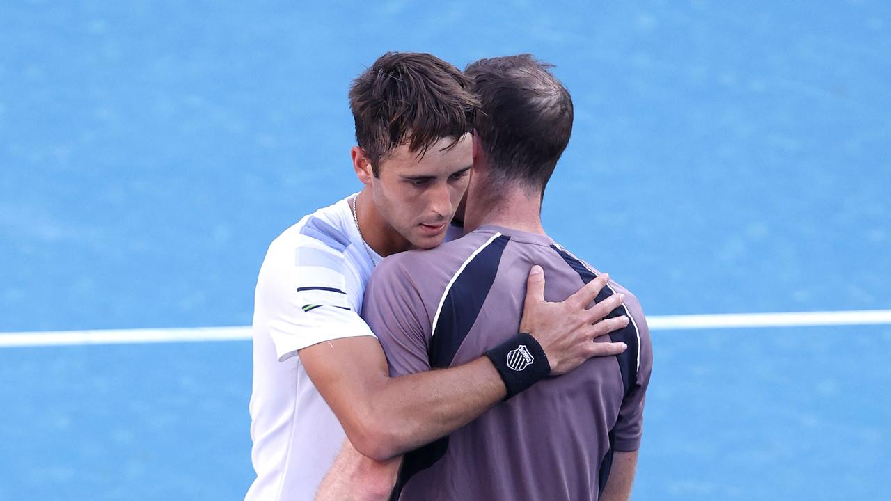 Argentina's Tomas Martin Etcheverry (left) hugs Murray at Melbourne Park. (Photo by Martin KEEP / AFP)