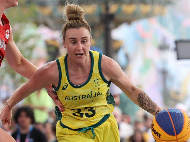 Australia's #33 Lauren Mansfield dribbles past Canada's #02 Katherine Plouffe (L) in the women's pool round 3x3 basketball game between Australia and Canada during the Paris 2024 Olympic Games at La Concorde in Paris on July 30, 2024. (Photo by David GRAY / AFP)