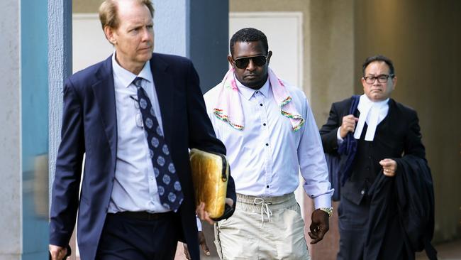 Eddie Epseg (centre), who has pleaded not guilty to eight charges of rape and one charge of choking leaves the Cairns Court House with his legal counsel. Picture: Brendan Radke