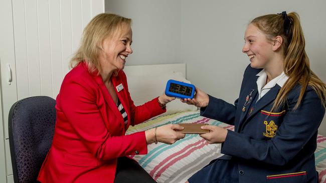 St Hilda's Principal Dr Julie Wilson Reynolds with student Anna Finlayson, swapping a phone for an alarm clock. Picture: Jerad Williams