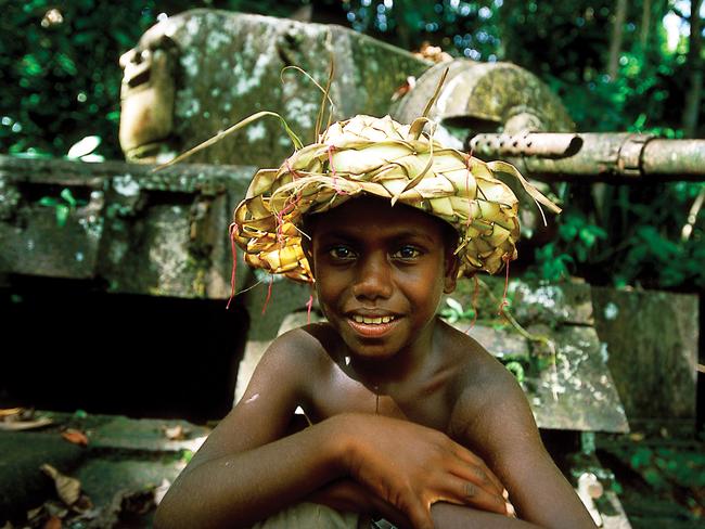 A village boy in front of a US WWII tank on Kohinggo Island. Picture: Kirkland Images