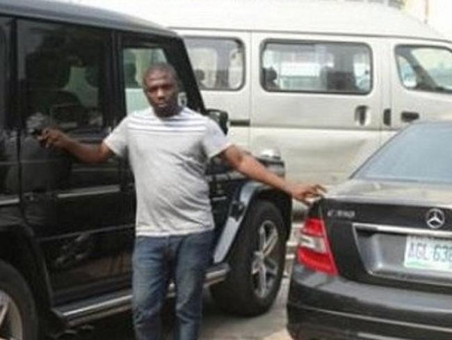 Hope Aroke posing with cars he brought from the profits.