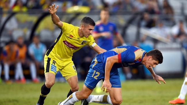 Harrison Sawyer (right) of the Jets is tackled by Nick Montgomery of the Mariners during the round 26 A-League match between the Central Coast Mariners and the Newcastle Jets at Central Coast Stadium in Gosford on Sunday, April 9, 2017. (AAP Image/Paul Miller)