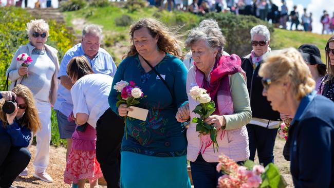 Shanelle Dawson and Pat Jenkins, sister of Lynette, lay flowers during the Walk for Lyn Dawson at Long Reef Surf Club in Sydney NSW, 2018. Picture: AAP