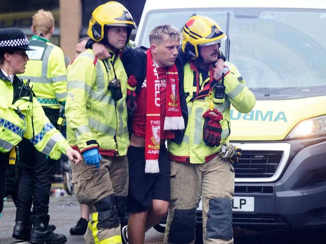 A man is helped by police and emergency personnel. Picture: Owen Humphreys/PA via AP