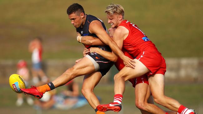 Josh Kelly gets a kick away in a pre-season practice match against the Swans