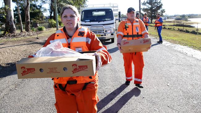 SES volunteer Kate Vendrasco from Mt Druitt SES loads carries dog food which was rowed into isolated houses in Llandilo. <i>Picture: News Corp</i>