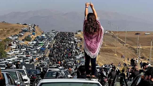 An unveiled woman stands on top of a vehicle as thousands make their way towards Aichi cemetery in Saqez, Mahsa Amini's home town in the western Iranian province of Kurdistan, to mark 40 days since her death.