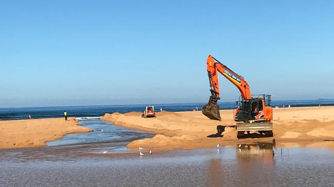 The council regularly has to open a channel to allow Narrabeen Lagoon to open to the ocean at North Narrabeen Beach. Picture: Manly Daily