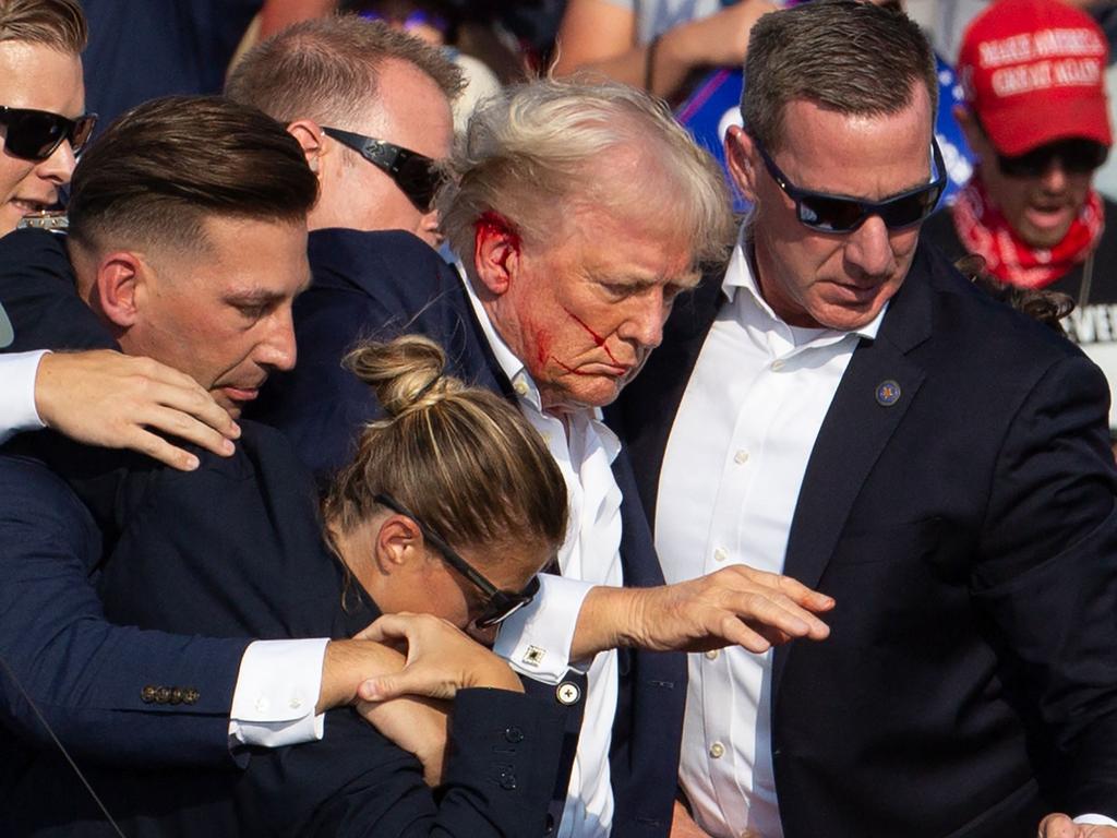 Donald Trump is surrounded by secret service agents after he was hit by a bullet during a rally in Pennsylvania. Picture: AFP