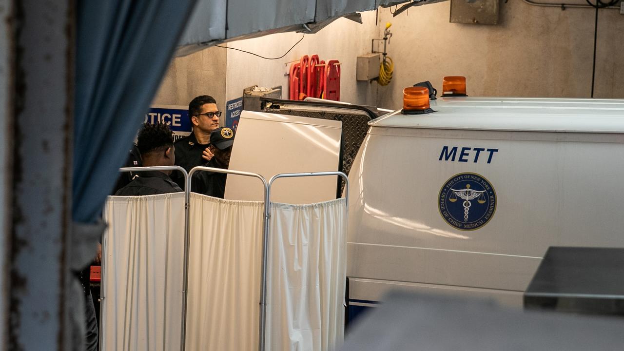 Police officers cover a medical examiner car outside New York Presbyterian-Lower Manhattan Hospital where Jeffrey Epstein's body was transported. Picture: Reuters/Jeenah Moon