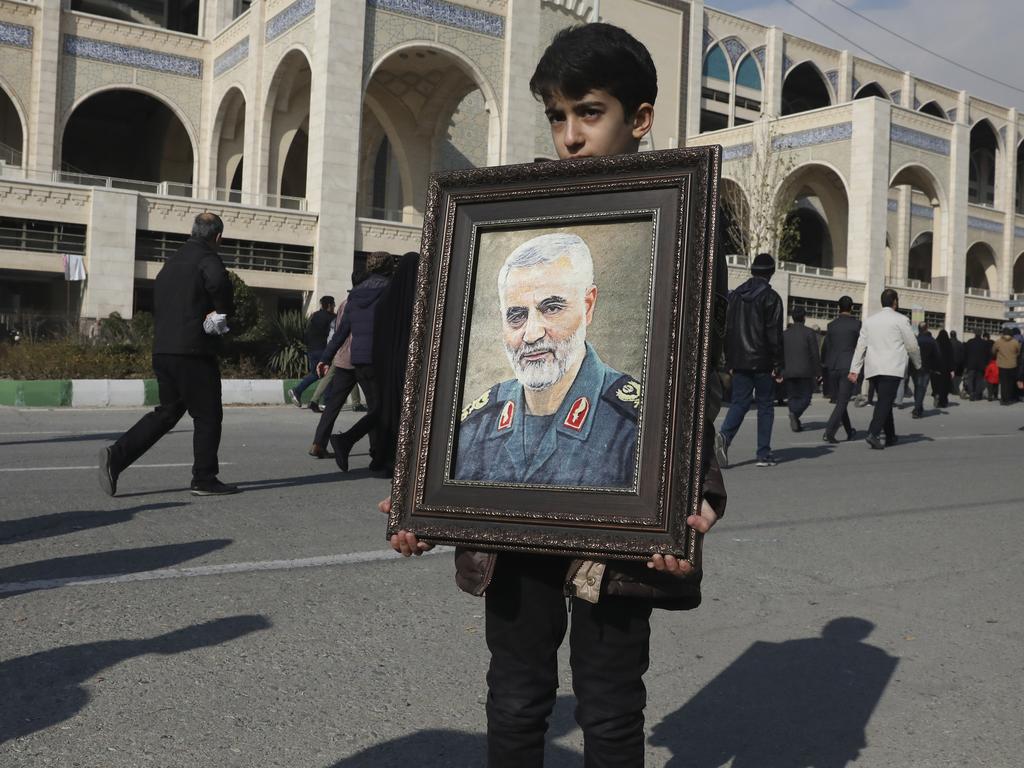 A boy carries a portrait of General Qassem Soleimani. Picture: AP/Vahid Salemi.