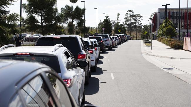 A line of cars waiting to access a testing station set-up at Orion Springfield Central Shopping Centre. Picture: News Corp/Attila Csaszar