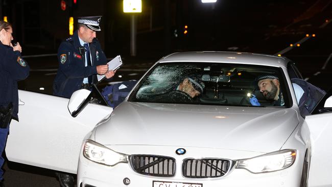 Police inspect the BMW after the crash. Picture: Bill Hearne